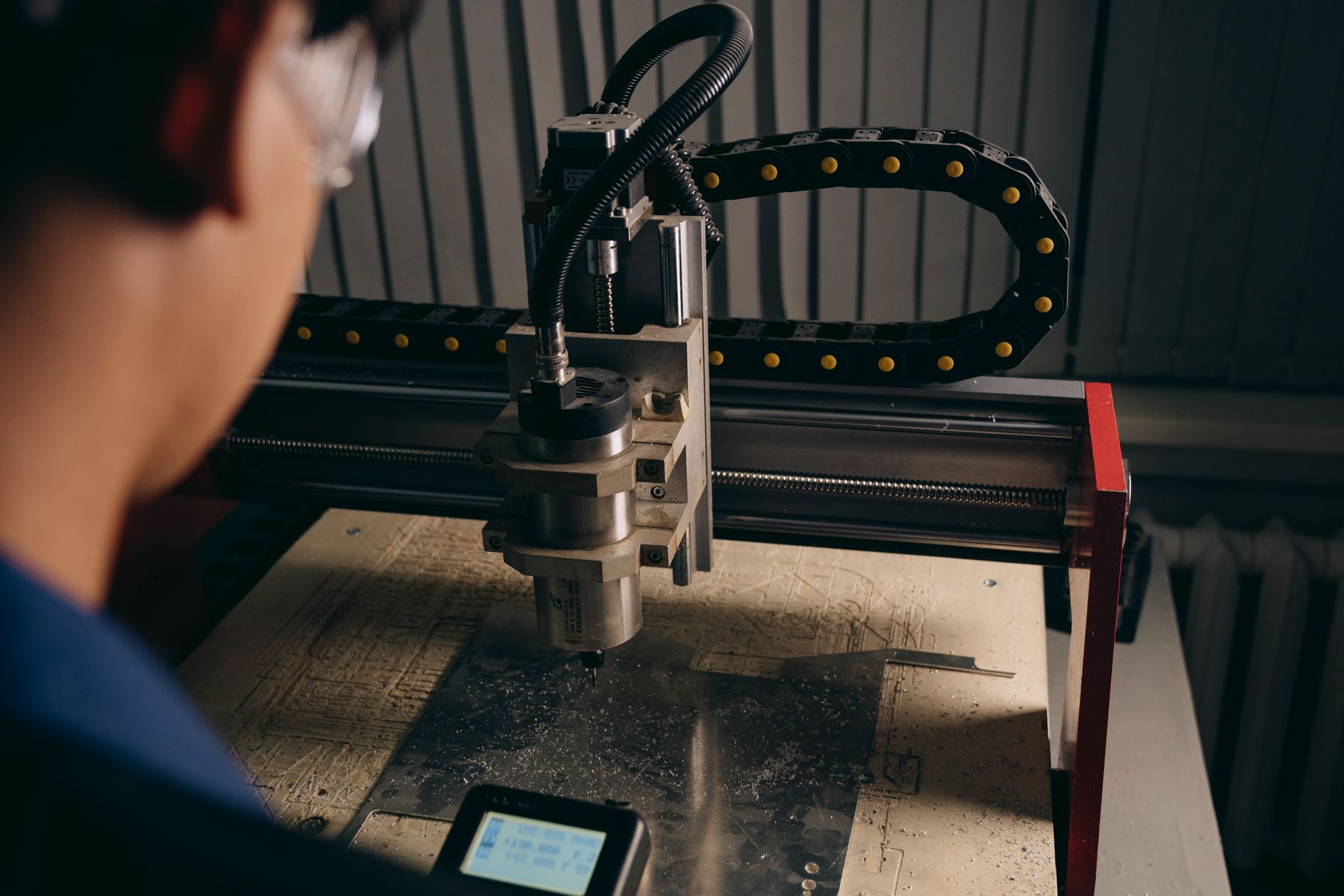 Un operatore segue la lavorazione su una macchina CNC in officina